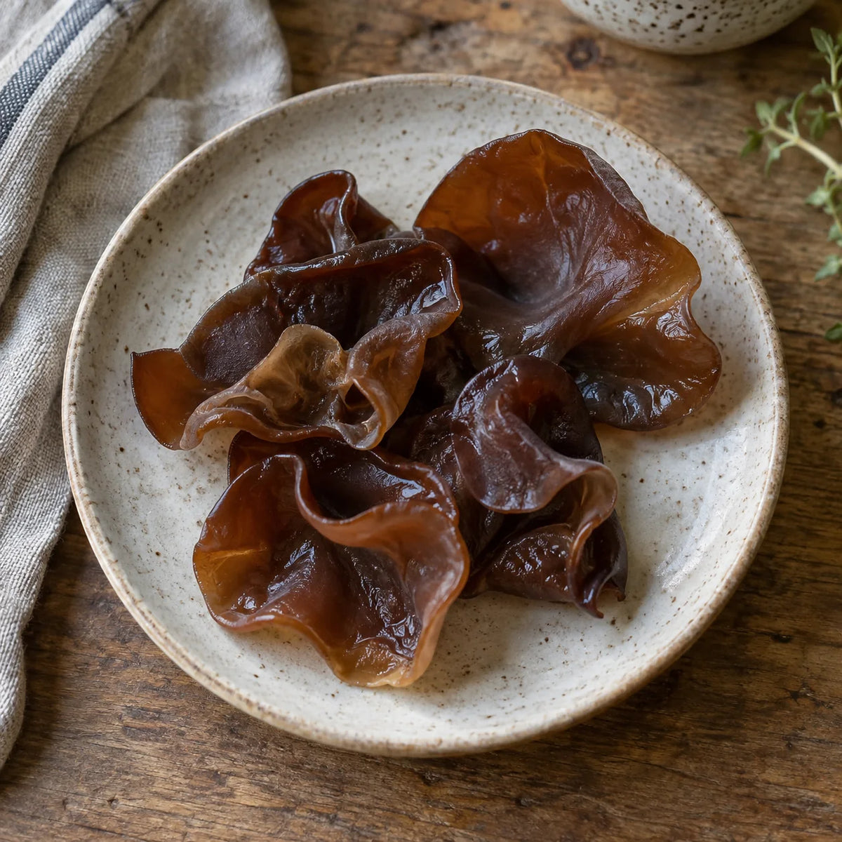 Champignons noirs frais sur une assiette en grès clair.