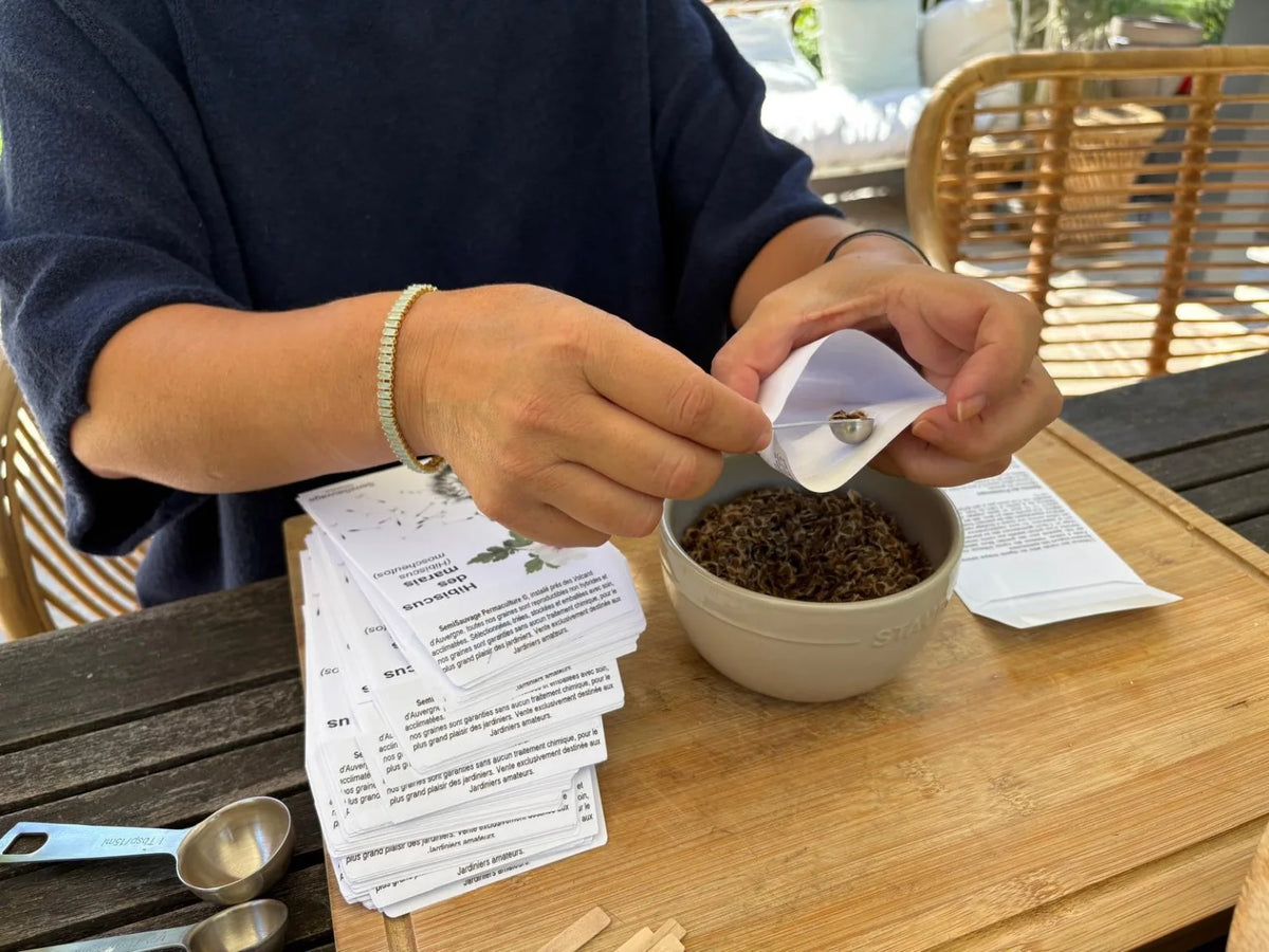 Mise en sachet de graines à la main, avec une cuillère doseuse, chez SemiSauvage.
